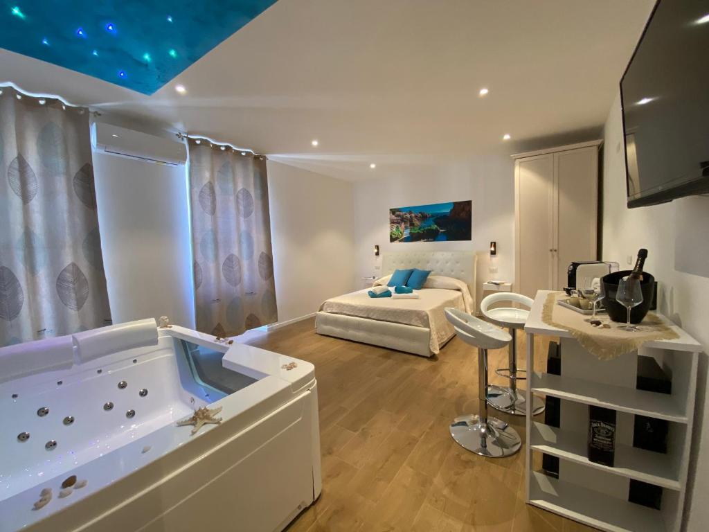 uma casa de banho com banheira e uma cama num quarto em Le Calette 105 em Alghero