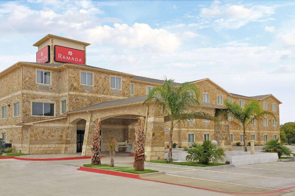 a large building with a sign on top of it at Ramada by Wyndham South Waco in Hewitt