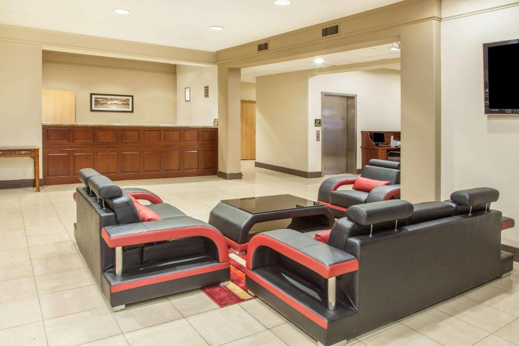 una sala de espera con sofás y TV de pantalla plana. en Hawthorn Suites Bloomington, en Bloomington