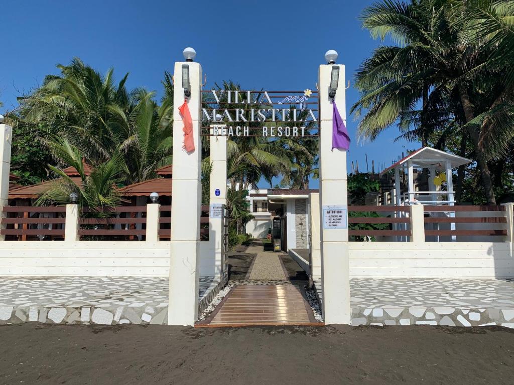 Villa MJ Maristela Beach Resort في Lemery: بوابة للمنتجع عليها لافته