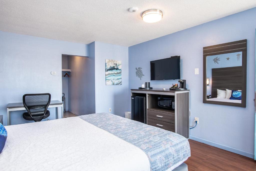 a hotel room with a bed and a flat screen tv at Aqua Breeze Inn in Santa Cruz