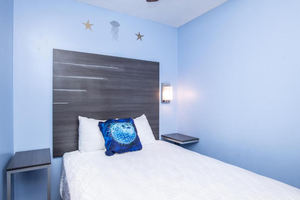 a bedroom with a white bed with a blue pillow at Aqua Breeze Inn in Santa Cruz