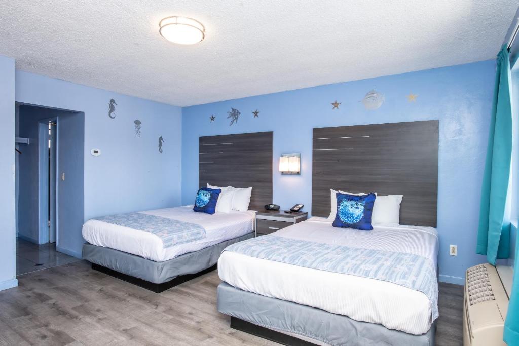 two beds in a room with blue walls at Aqua Breeze Inn in Santa Cruz