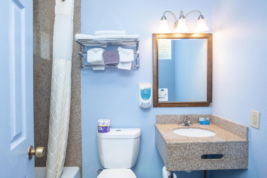 a bathroom with a toilet and a sink and a mirror at Aqua Breeze Inn in Santa Cruz