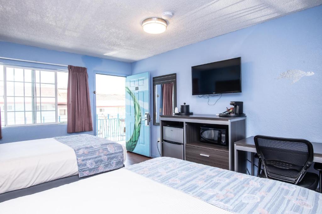 a hotel room with two beds and a flat screen tv at Aqua Breeze Inn in Santa Cruz
