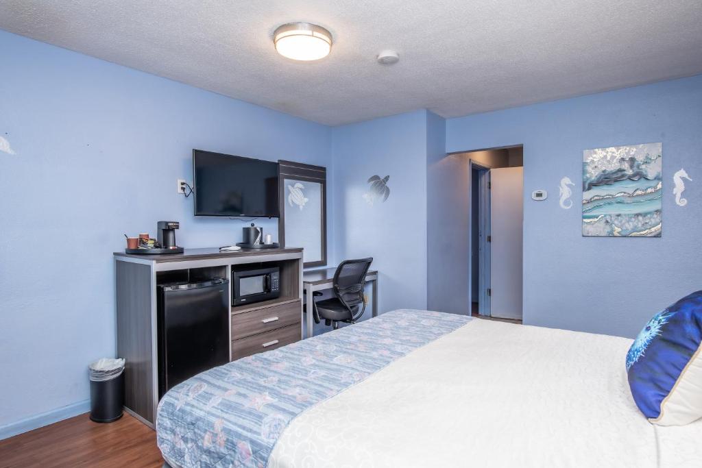 a bedroom with a bed and a desk and a tv at Aqua Breeze Inn in Santa Cruz