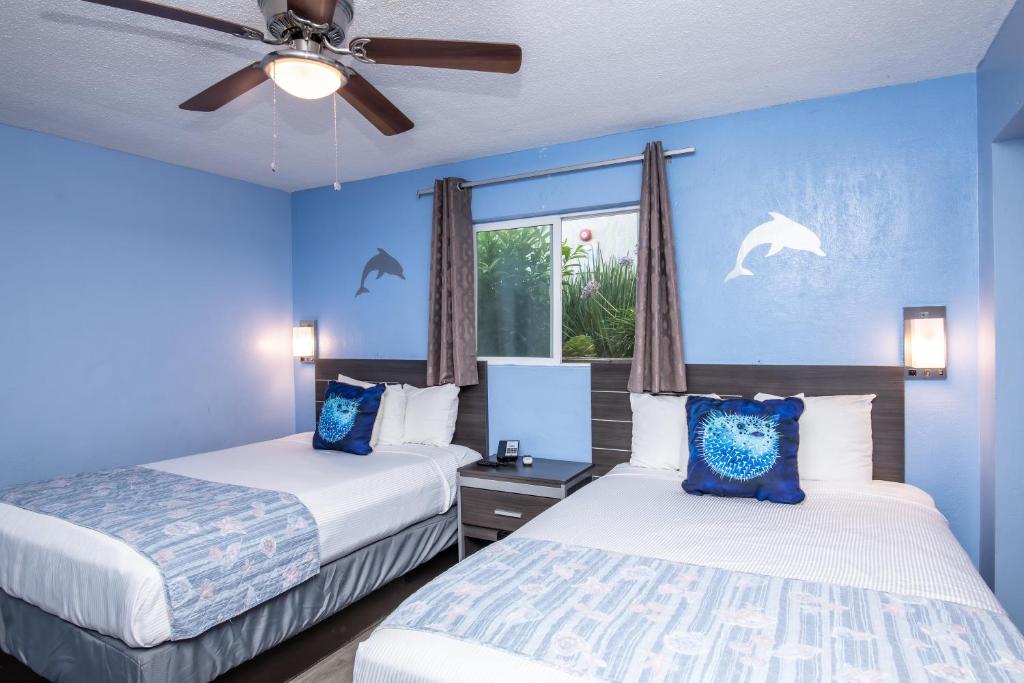 two beds in a room with blue walls at Aqua Breeze Inn in Santa Cruz