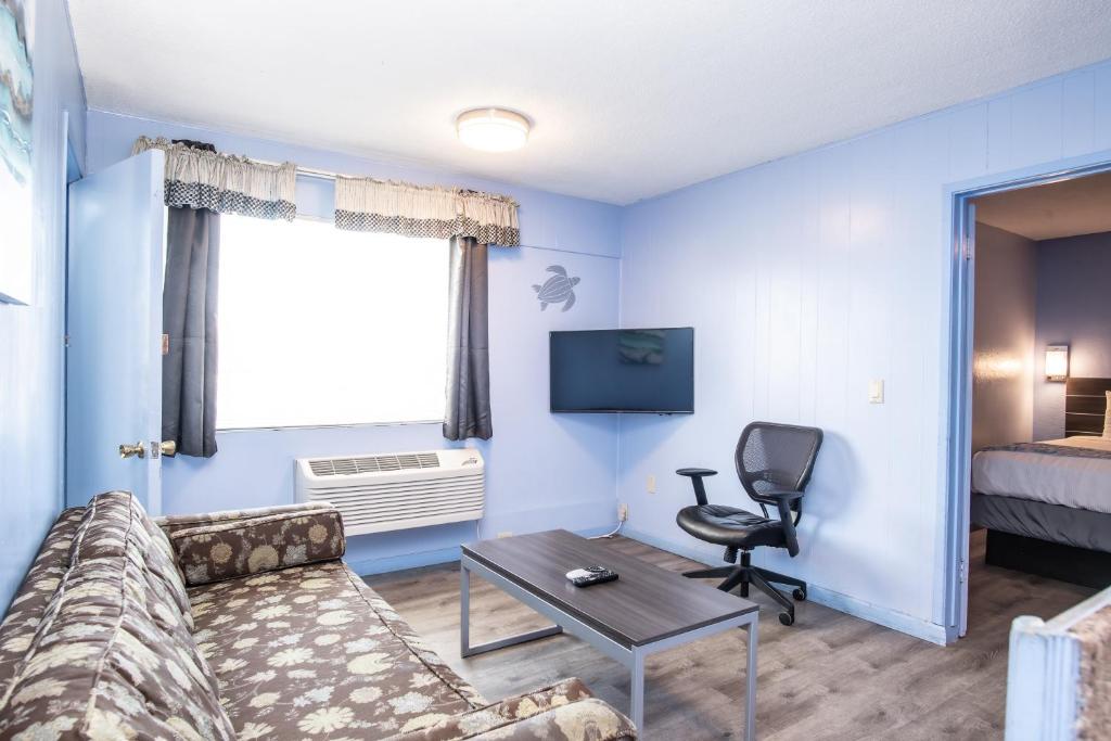 a living room with a couch and a table and a bed at Aqua Breeze Inn in Santa Cruz