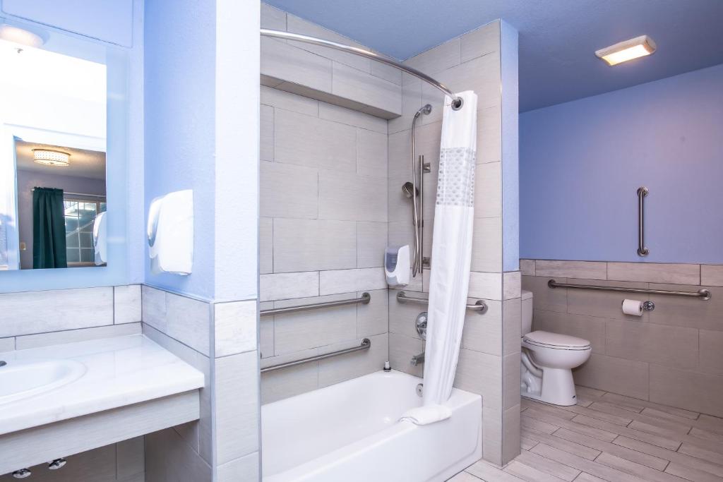 a bathroom with a tub and a sink and a toilet at Aqua Breeze Inn in Santa Cruz