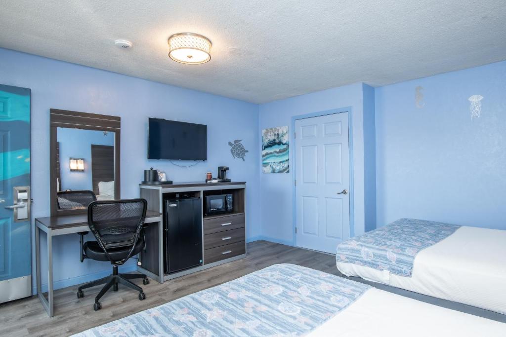 a bedroom with blue walls and a bed and a desk at Aqua Breeze Inn in Santa Cruz