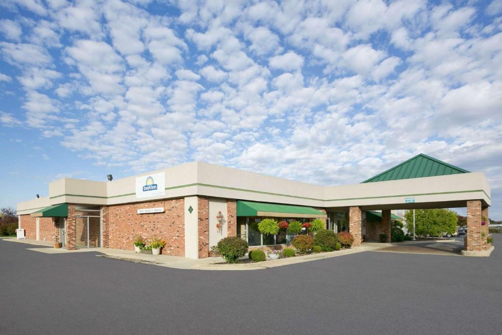 a store front with a cloudy sky in a parking lot at Days Inn by Wyndham Sidney OH in Sidney