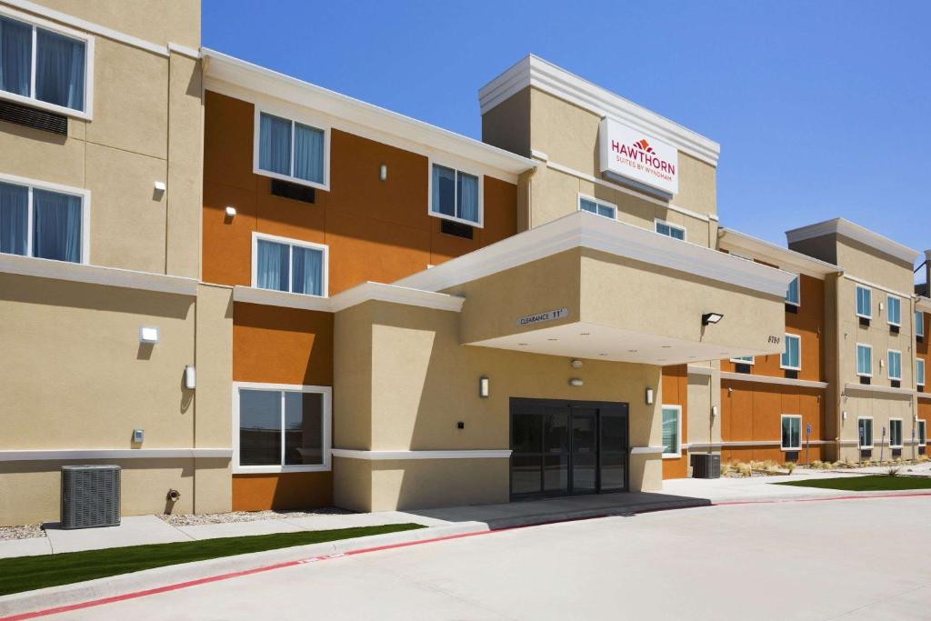 un bâtiment d'hôtel avec un parking en face de celui-ci dans l'établissement Hawthorn Suites by Wyndham San Angelo, à San Angelo