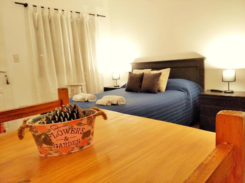 a bedroom with a bed and a table with a bowl of bottles at MG Suites in Monte Grande