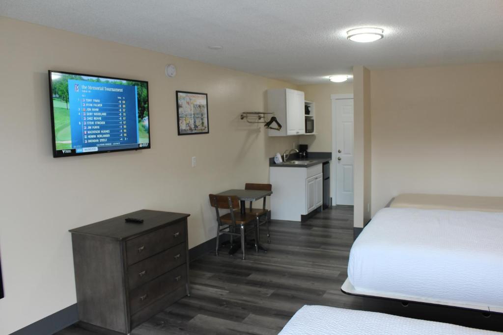 a bedroom with a bed and a desk and a kitchen at Inn at the Sea in Long Beach