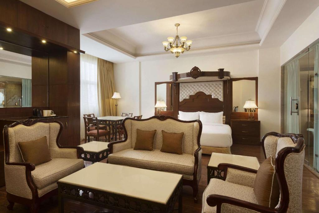 a hotel room with a bed and chairs and a table at Ramada Plaza By Wyndham, Chandigarh Zirakpur in Chandīgarh