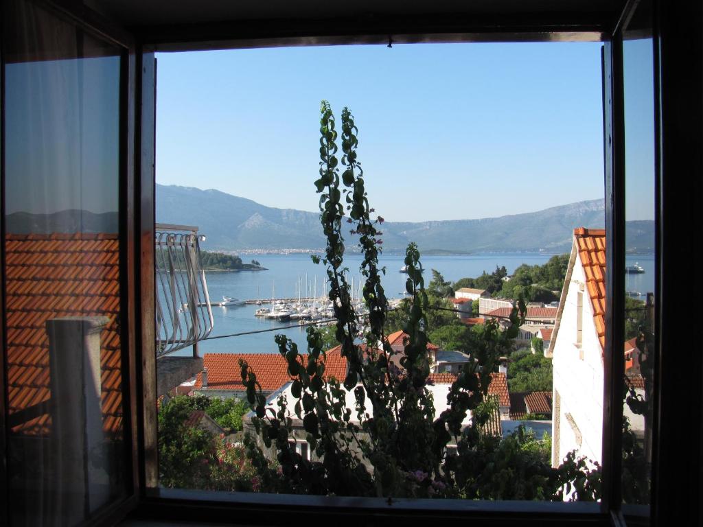a window with a view of a body of water at Apartments Lumbarda in Lumbarda