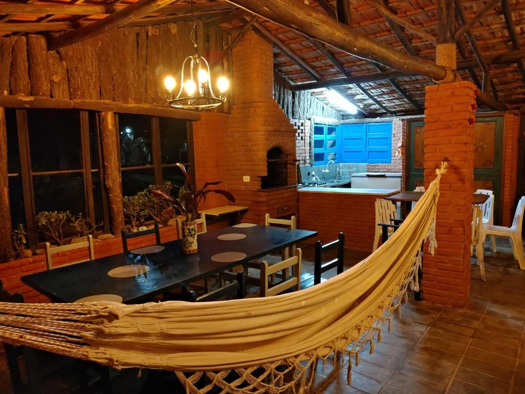 a hammock in a room with a table and a kitchen at Recanto do Luar in Pinhalzinho