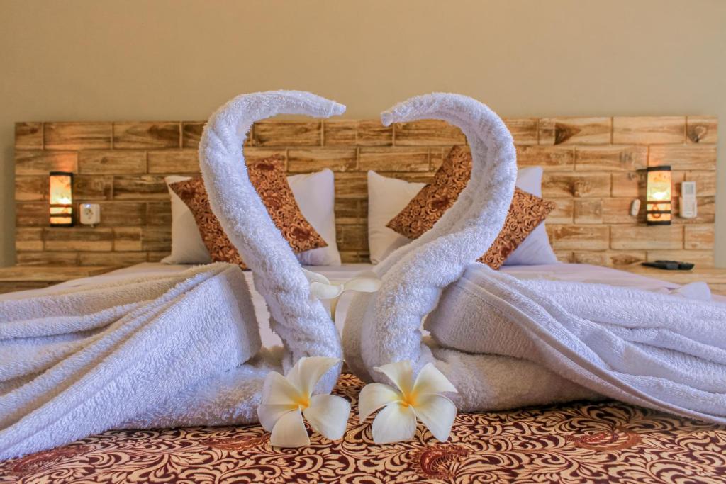 a bed with two swans made out of towels at Hotel Niki in Jembrana