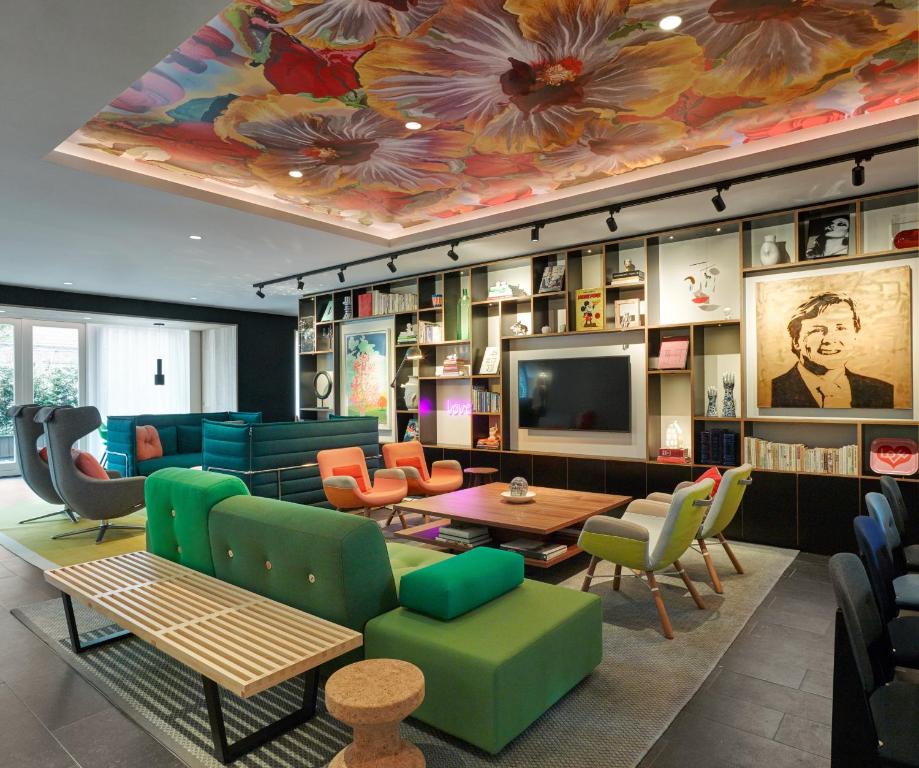 a living room with colorful furniture and a tv at citizenM Amstel Amsterdam in Amsterdam