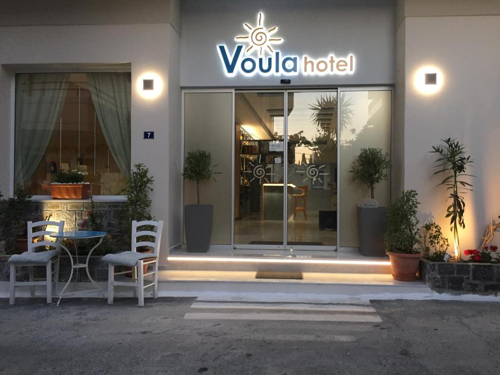 Voula Hotel في خيرسونيسوس: فندق فولولا مع كراسي وطاولة في الأمام