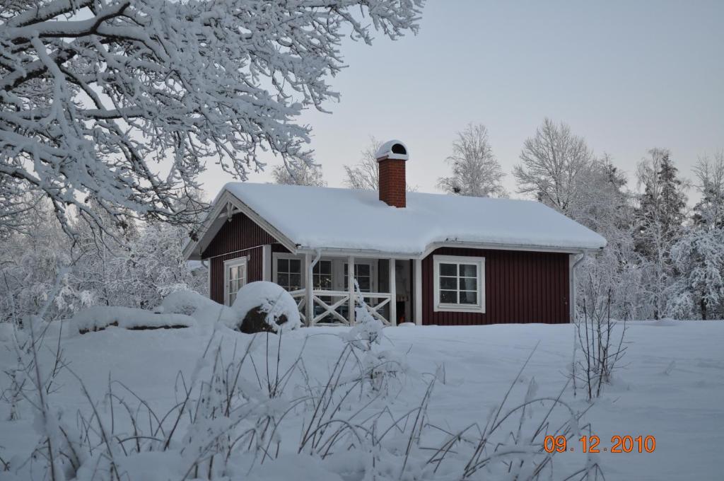 mały domek pokryty śniegiem z przodu w obiekcie Wismens Natur & Fiske w mieście Krogsered