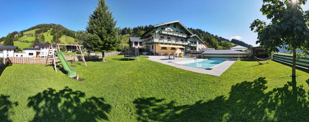 a large yard with a playground and a house at Appartements Tannenhof in Wagrain