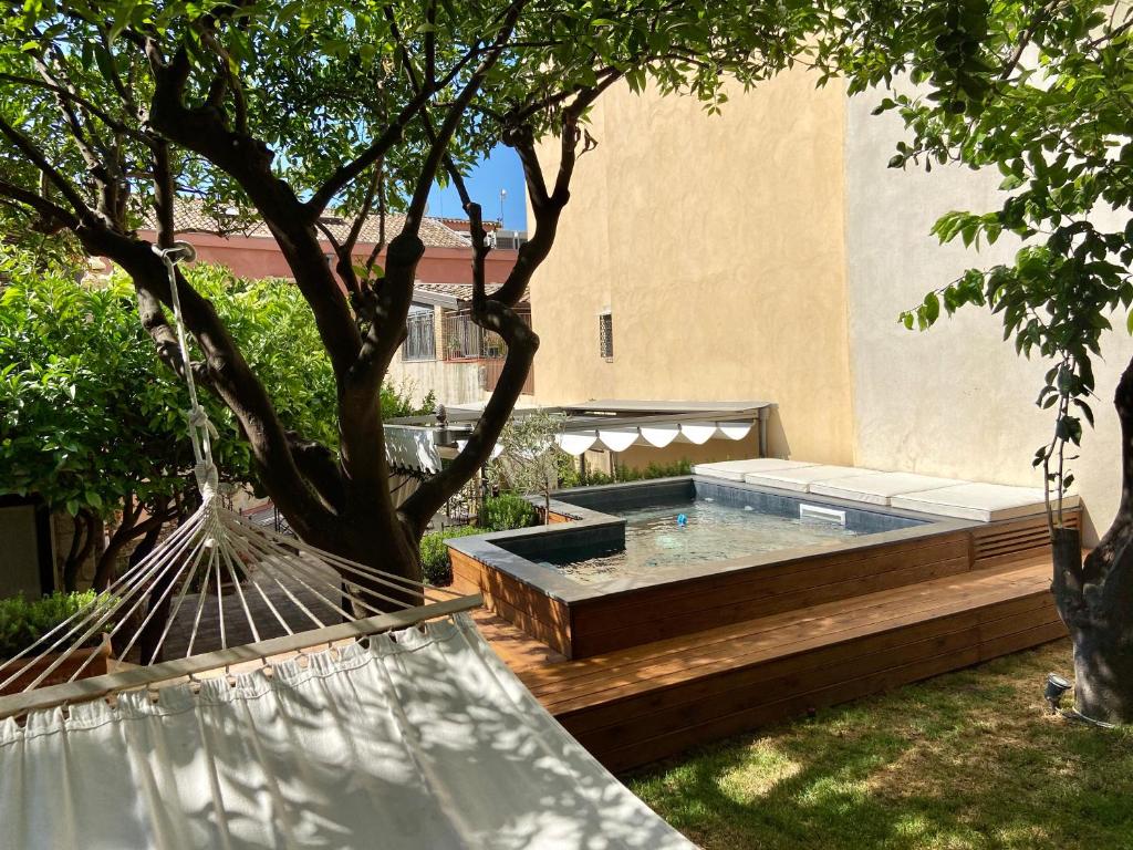 a backyard with a hot tub and a tree at Relais 147 - Luxury b&b in Taormina