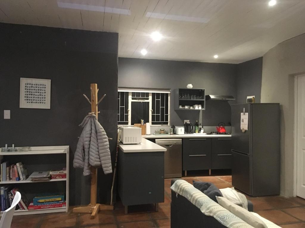 une cuisine avec des armoires noires et un comptoir blanc dans l'établissement Bramber Cottage Hogsback, Living With Joy!, à Hogsback