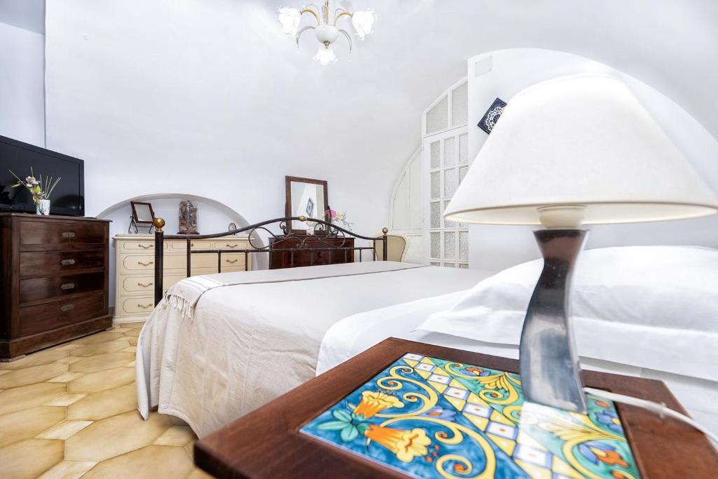 1 dormitorio con 1 cama y 1 mesa con lámpara en Il Nido Casa Vacanze, en Atrani
