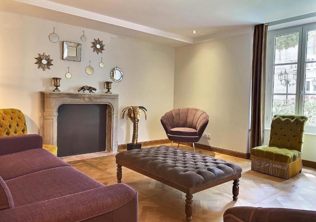a living room with a couch and a chair and a fireplace at Le Tardif, Noble Guesthouse in Bayeux