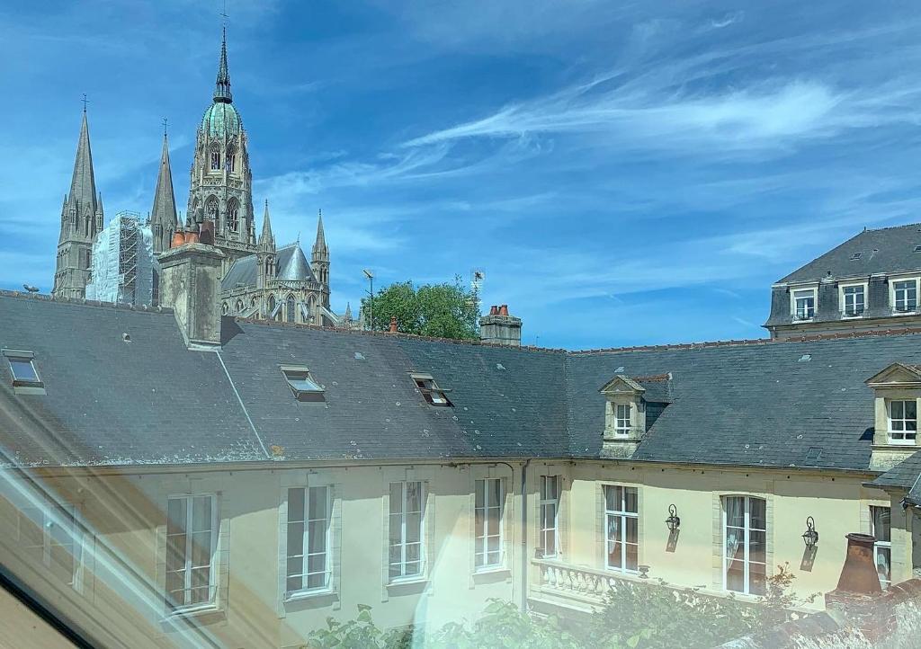 a view of a building with towers in the background at Le Tardif, Noble Guesthouse in Bayeux