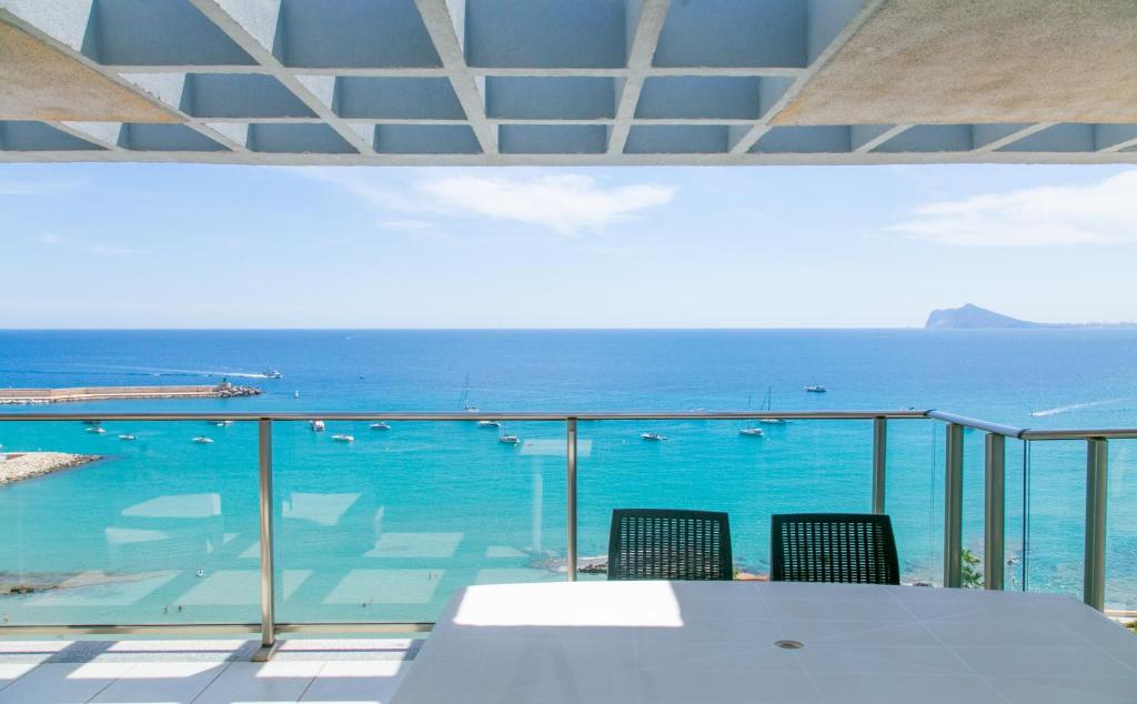 a view of the ocean from a balcony with a table and chairs at Sotavento Atico Calpe in Calpe