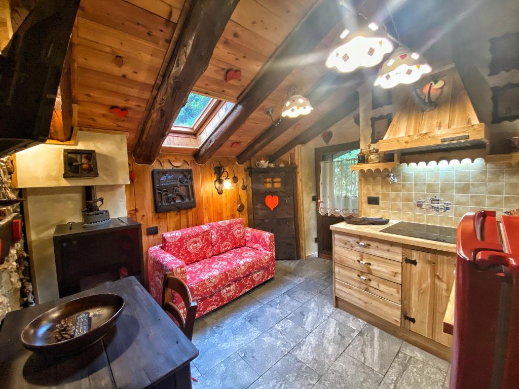 a kitchen with a red couch in a room at La Maisonnette de Stefano in Pré-Saint-Didier