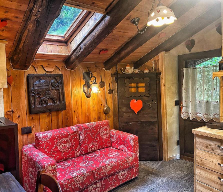 a red couch in a room with a wooden wall at La Maisonnette de Stefano in Pré-Saint-Didier
