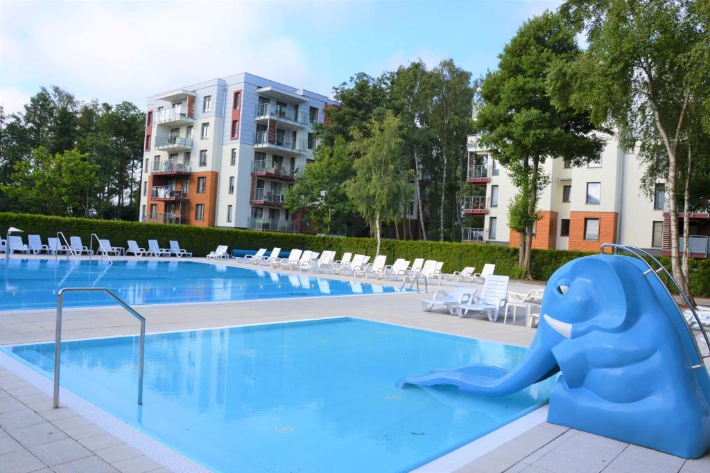 a swimming pool with a blue elephant in the middle at Apartament H204 z widokiem na basen in Kołobrzeg