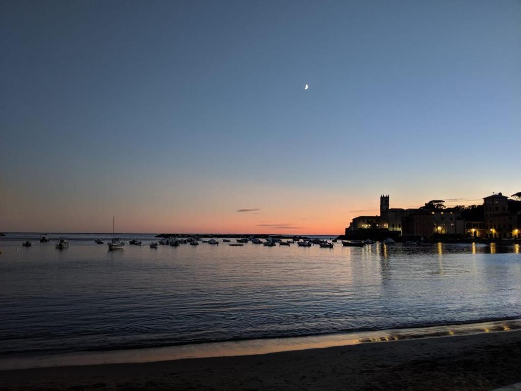 a beach with boats in the water at sunset at Hotel Miramare & Spa in Sestri Levante