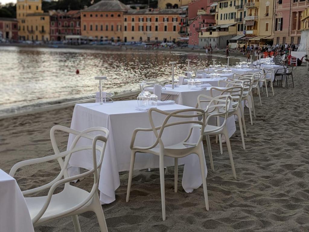 a row of tables and chairs on a sandy beach at Hotel Miramare & Spa in Sestri Levante