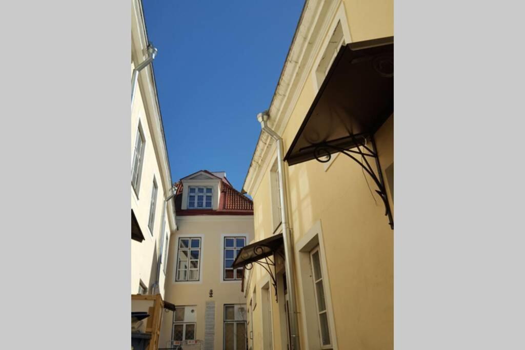 um beco entre dois edifícios com um céu azul ao fundo em Old Town Baltic Antique Lai street Privat entrance em Talin