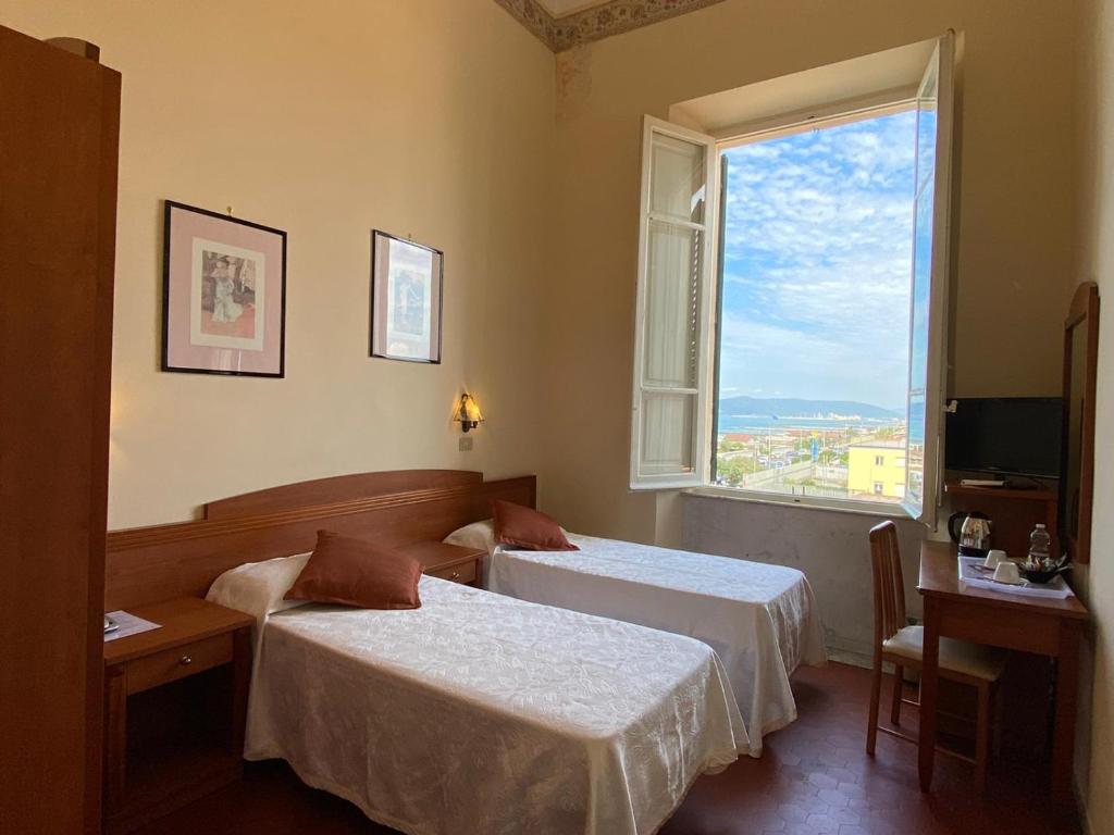 pokój hotelowy z dwoma łóżkami i oknem w obiekcie Hotel Italia w mieście Marina di Massa