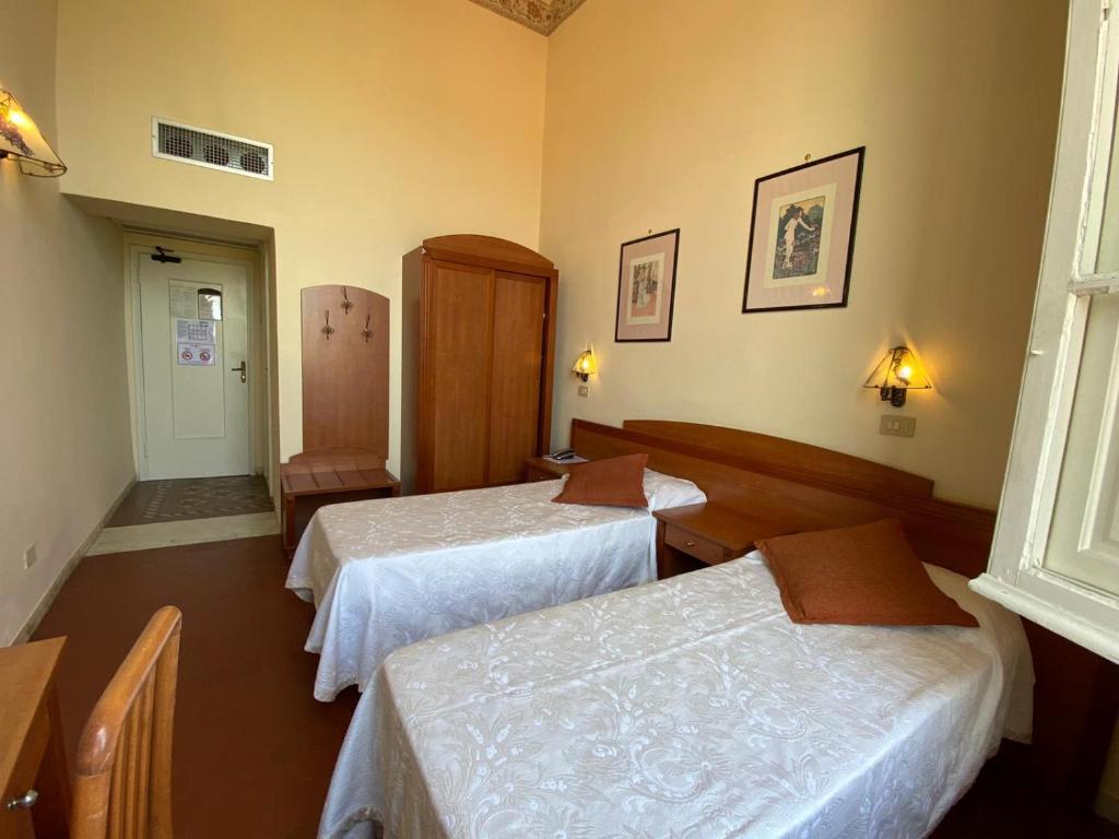 Łóżko lub łóżka w pokoju w obiekcie Hotel Italia