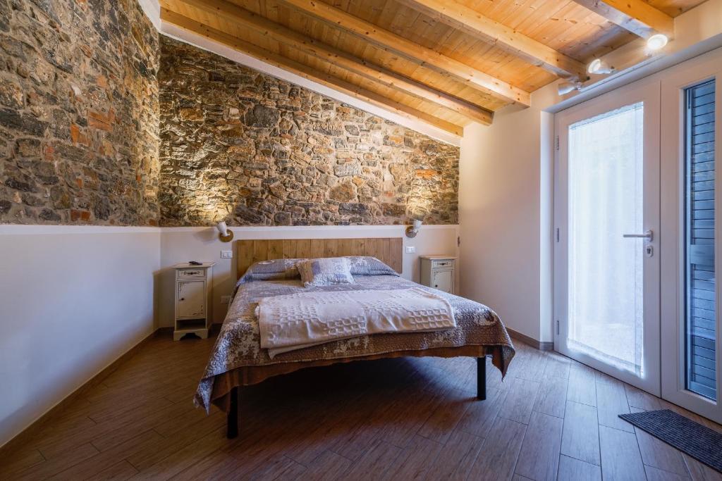 - une chambre avec un lit et un mur en briques dans l'établissement La corte dei tre, à Torre del Lago Puccini