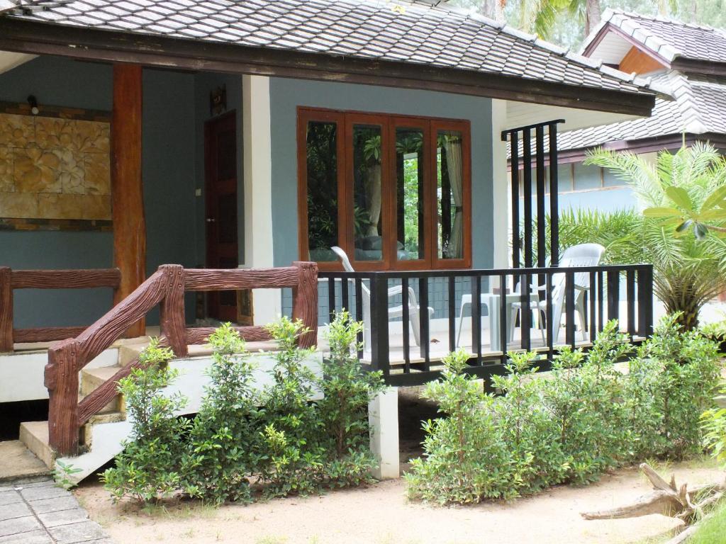 a house with a porch with a wooden railing at Bottle Beach 1 Resort in Bottle Beach