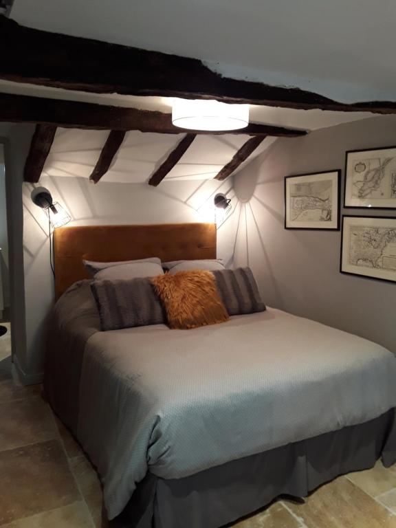 a bedroom with a large bed with a wooden headboard at Les Charmes du Lac in Esclauzels