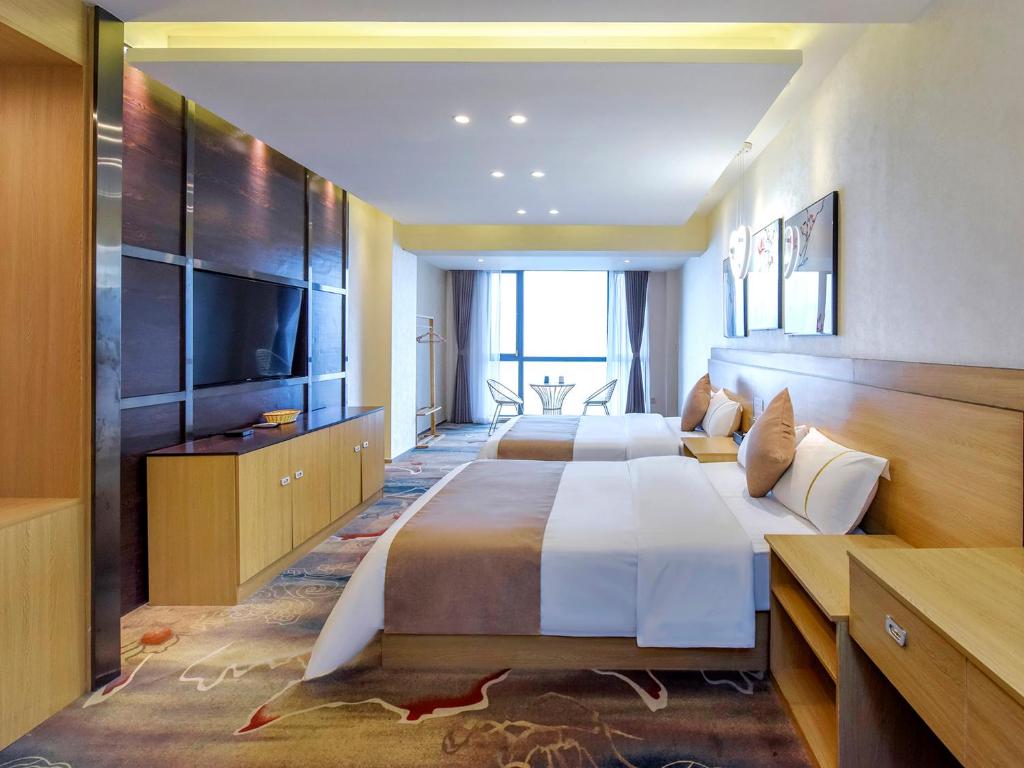 a hotel room with two beds and a flat screen tv at Chongqing Ouranjian Lake View Guesthouse in Chongqing