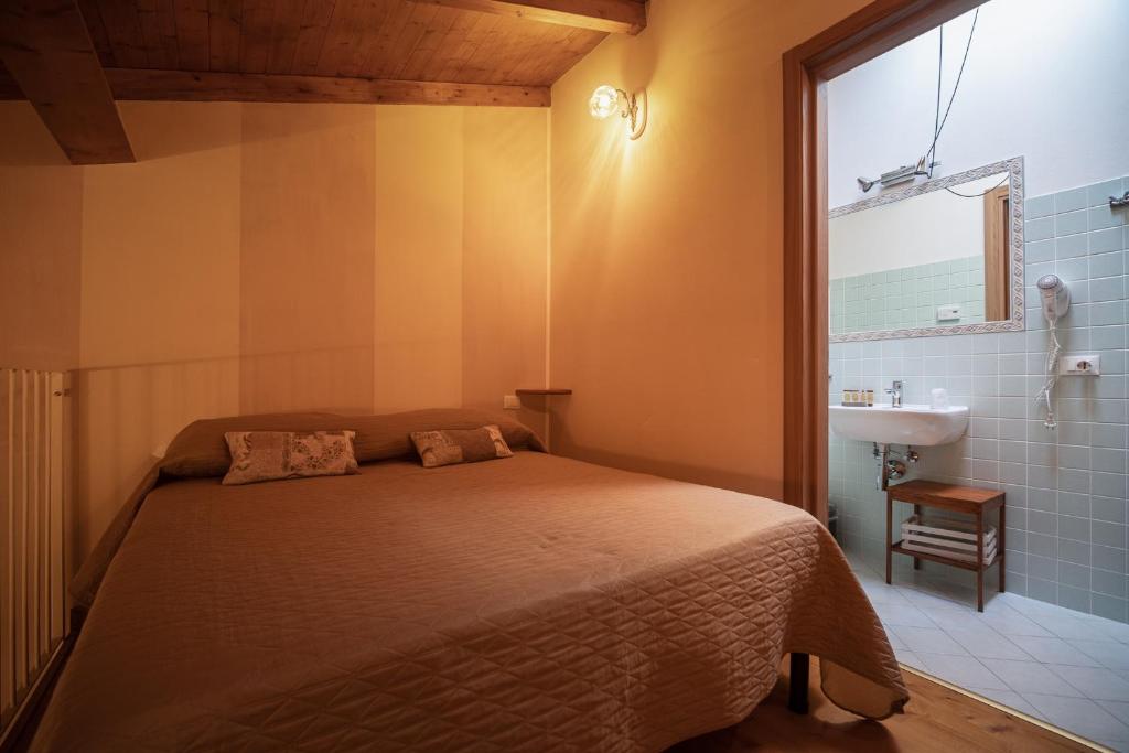 a bedroom with a bed and a sink and a window at La corte dei tre in Torre del Lago Puccini