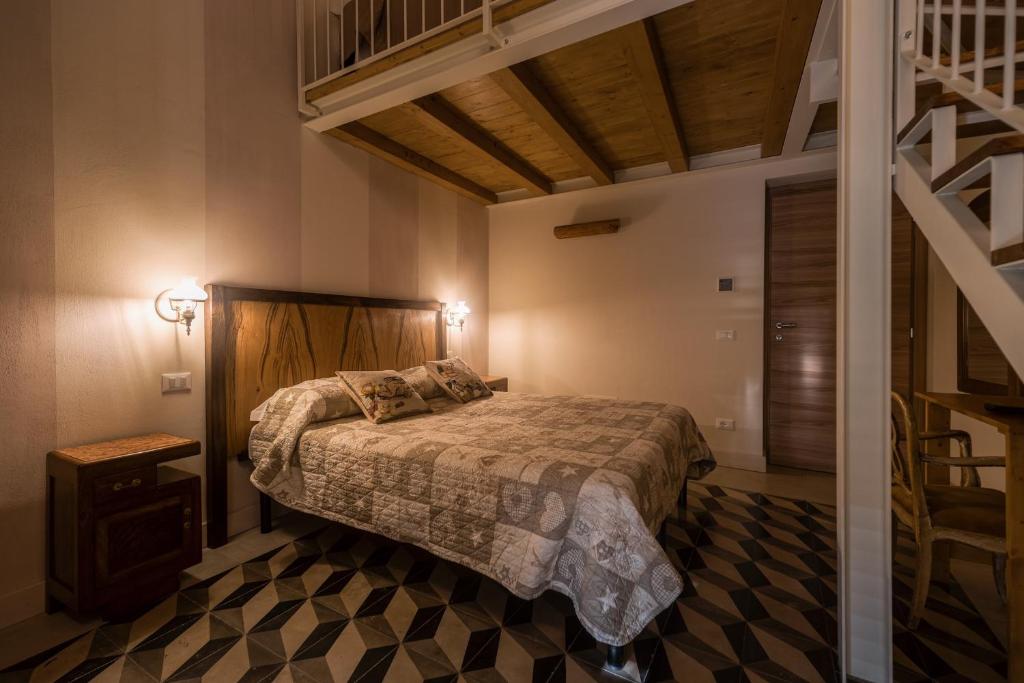 a bedroom with a bed in a room with a staircase at La corte dei tre in Torre del Lago Puccini