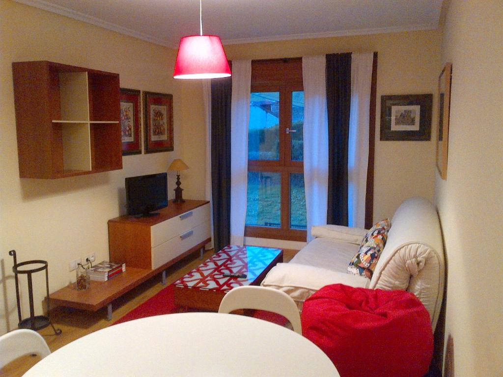 ein Wohnzimmer mit einem Sofa und einem TV in der Unterkunft Apto. de Montaña La Campa en Felechosa (Aller) in Felechosa