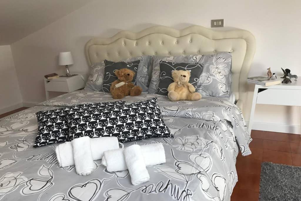 dos ositos de peluche sentados en una cama con almohadas en MODULAR ATTIC 3 PERUGIA A 4 KM MURA CENTRO STORICO, en Perugia