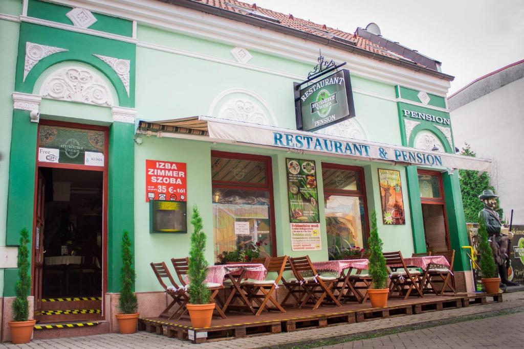 a restaurant with tables and chairs outside of a building at Hubert Varga in Komárno