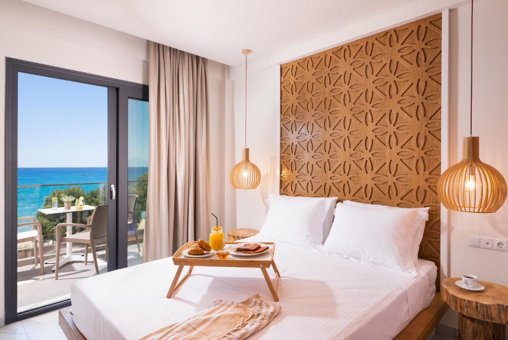 a bedroom with a bed and a view of the ocean at Acron Suites in Limenaria